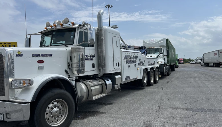 Heavy-duty wrecker towing commercial box truck in Austin TX