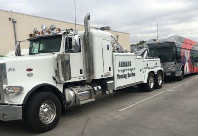 Armada Towing Service heavy-duty wrecker towing passenger bus