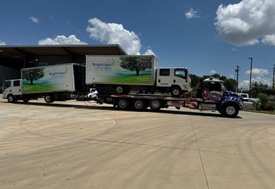 Armada Towing Service rollback tow truck carrying commercial flatbed truck