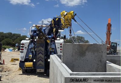 Armada Towing Service rotator lifting concrete vault structures on job site