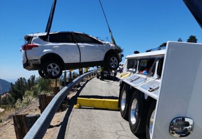 Armada Towing Service rotator recovering SUV over highway embankment